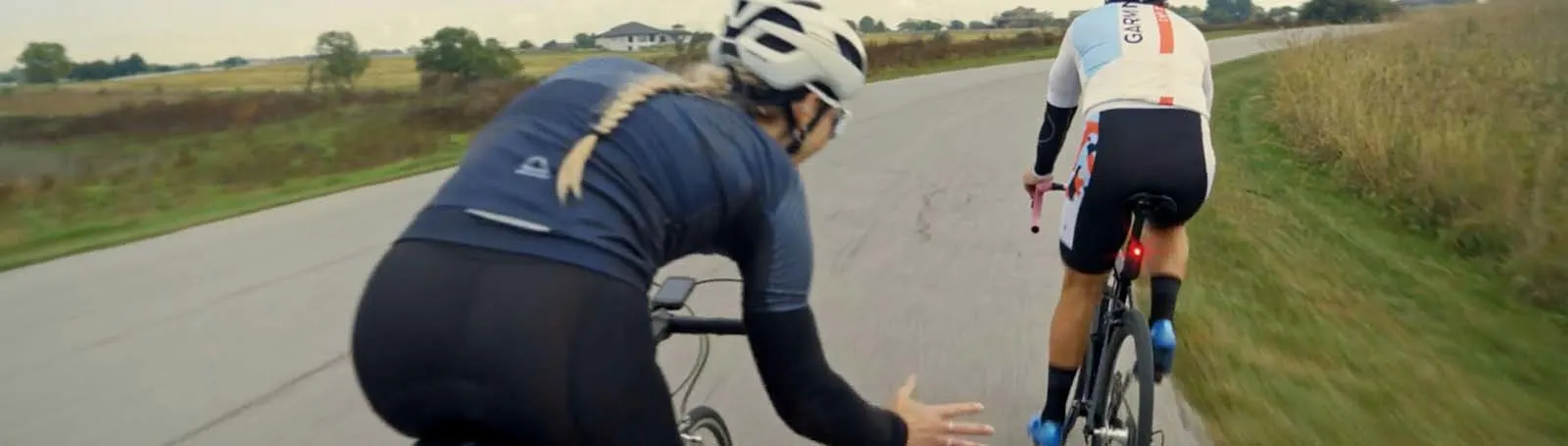 a couple of people riding bikes on a road