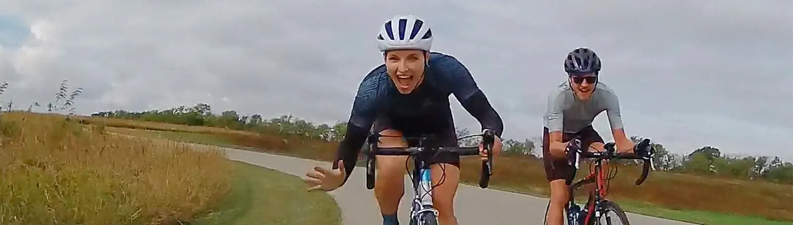 a couple of men riding bikes on a road